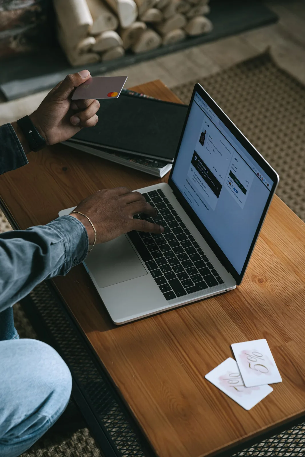 Osoba robiąca zakupy online na laptopie z kartą płatniczą w ręku